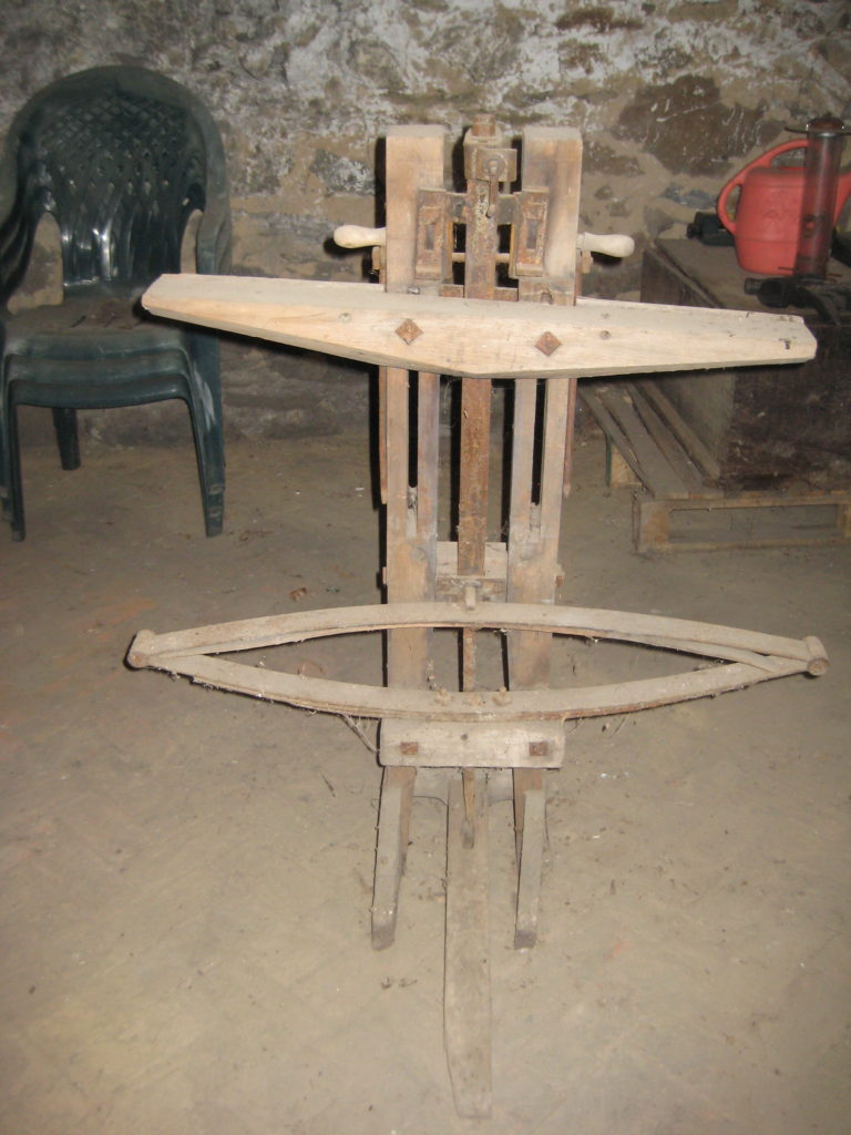 Unidentified wood device with metal parts, square nuts, and washer nuts, and hex nuts in basement of Melville House