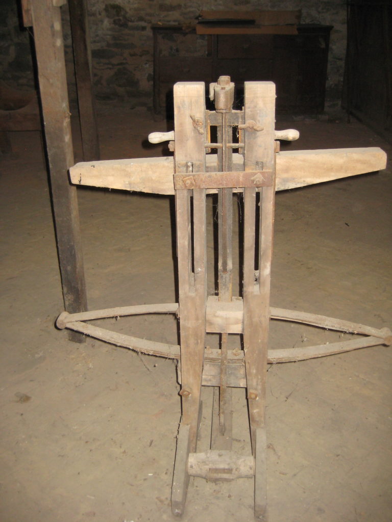 Unidentified wood device with metal parts, square nuts, and washer nuts, and hex nuts in basement of Melville House, reverse side