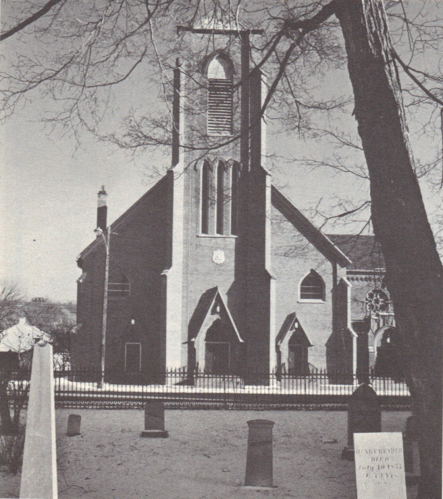 Black and white photo of front of St. Augustine's church taken from the churchyard of Trinity.